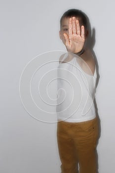 A boy in a white T-shirt stands, closes his palm, the concept of protest, close-up