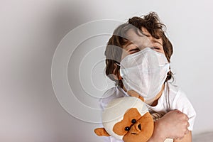 Boy in white tshirt and protective medical mask closed his eyes and afraid with toys monkey on white background. Fight with