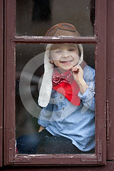 Boy on the window, laughing and drinking tea