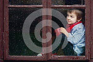 Boy on the window, laughing and drinking tea