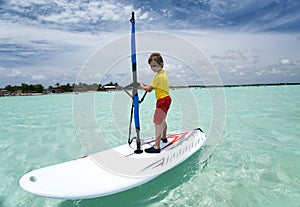 Boy on windsurfing board.