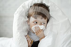 Boy wipes his nose with tissue