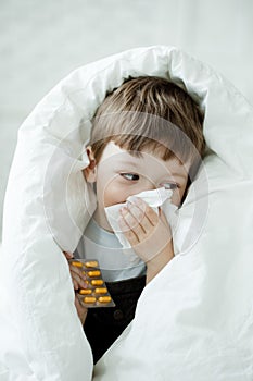 Boy wipes his nose with tissue