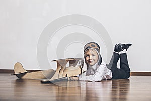 Boy with wooden plane model and a cap with cap designs