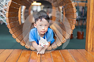 A boy is in a wooden tunnel