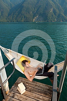 Boy working on hamaca on the lake photo