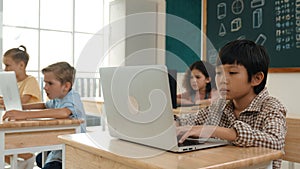 Boy working on his laptop while learning about coding prompt at class. Pedagogy.