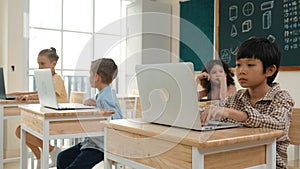 Boy working on his laptop while learning about coding prompt at class. Pedagogy.