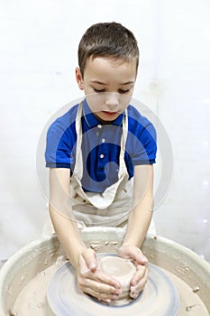 Boy working at pottery wheel
