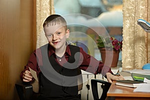 The boy works in his office on a personal computer.With a sticker in hand...