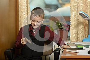 The boy works in his office on a personal computer.With a sticker in hand...