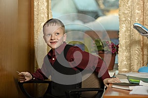 The boy works in his office on a personal computer.With a sticker in hand...