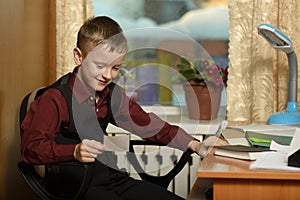 The boy works in his office on a personal computer.With a sticker in hand...