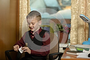 The boy works in his office on a personal computer.With a sticker in hand...