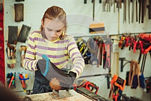 Boy in the workshop makes crafts with coconut. Young carpenter working in craft workshop. Creative student doing his project in