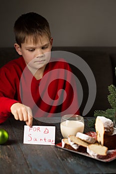 A boy writes a note to Santa and prepares a treat