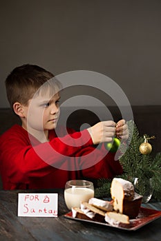 A boy writes a note to Santa and prepares a treat