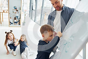 Boy writing on the board. Group of children students in class at school with teacher