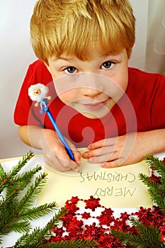 Boy writing Christmas wishes