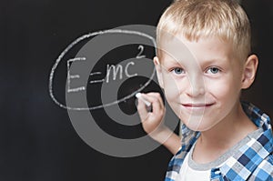 Boy writing formula of energy