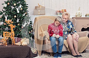 A boy writing letter to Santa with his grandmother