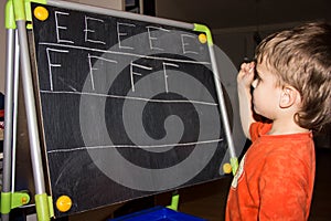 Boy writing letters learning process knowledge of small child