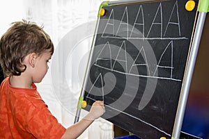 Boy writing letters learning process knowledge of small child