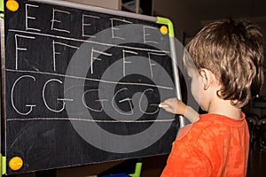 Boy writing letters learning process knowledge of small child