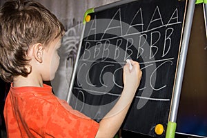 Boy writing letters learning process knowledge of small child