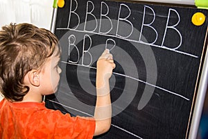 Boy writing letters learning process