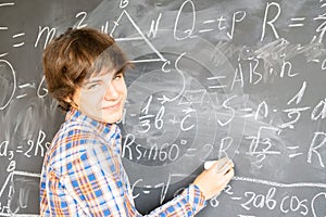 Boy writting on black board