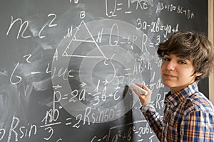 Boy writting on black board