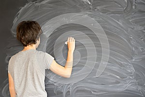 Boy writting on black board