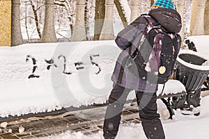 Boy wrongly decides an example on a snow-covered bench