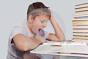 Boy yawns over homework