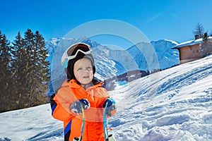 Boy 3 years old child with ski over mountains on background