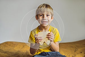 A boy, 6 years old, holds a box for milk teeth. Change of teeth