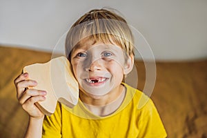 A boy, 6 years old, holds a box for milk teeth. Change of teeth