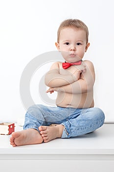 boy sitting on the floor in jeans and bow tie, little boss