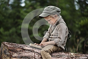 The boy, 5 years old, looks like a trapper, wanderer, lumberjack. photo