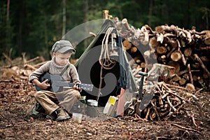 The boy, 5 years old, looks like a trapper, wanderer, lumberjack. photo