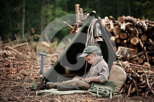 The boy, 5 years old, looks like a trapper, wanderer, lumberjack. photo