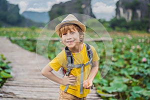 Boy in a yellow on the path among the lotus lake. Mua Cave, Ninh Binh, Vietnam. Vietnam reopens after quarantine