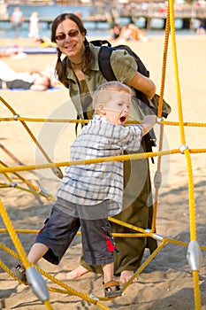 Boy on yellow ropes with mom