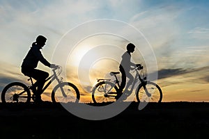 Boy and young girl riding bikes in countryside