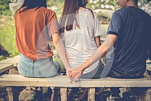 Boyfriend and another woman grab hands from behind together without sight of his girlfriend.. Paramour and divorce concept. Social