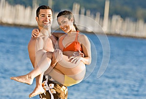 Boyfriend carrying girlfriend at beach
