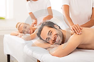 Boyfriend And Girlfriend Lying Enjoying Relaxing Massage At Spa Resort