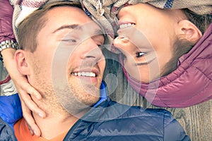 Boyfriend and girlfriend lying taking selfie outdoors with happy face expression looking each other in eyes. Couple of lovers photo