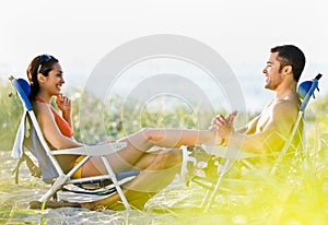 Boyfriend giving girlfriend foot massage at beach